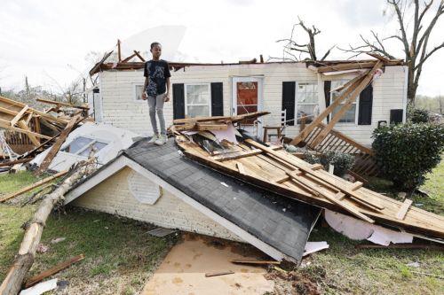 epa10546227 Aiden Gilliam stands on the roof of his house in the wake of a tornado in West Point, Georgia, USA, 27 March 2023. Tornadoes were confirmed in Georgia on 26 March two days after at least 25 people were killed in Mississippi after a tornado and severe weather outbreak on 24 March, according to the Mississippi Emergency Management Agency. ...