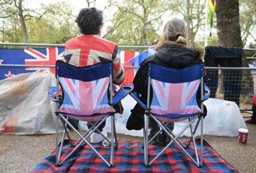 epa10610423 Royal fans wait on the coronation procession route on The Mall in London, Britain, 05 May 2023. Britain's King Charles III's coronation takes place at Westminster Abbey in London on 06 May 2023.  EPA/NEIL HALL