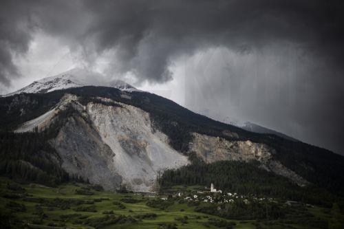 epa10623060 The village of Brienz/Brinzauls beneath the "Brienzer Rutsch", in Graubuenden, Switzerland, 12 May 2023. Two million cubic metres of rock from the mountain above the village are set to come loose and crash down to the valley in the imminent future. The village will be evacuated by this evening.  EPA/GIAN EHRENZELLER