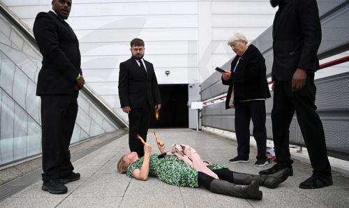 epa10647387 A protester lays on the ground after being carried out of the Shell General Shareholders meeting during a demonstration at the Excel Centre in London, Britain, 23 May 2023. Scores of protesters managed to gain access to Shell's Annual General Meeting (AGM) before being carried or escorted out. Demonstrators are calling for Shell to be shut down...