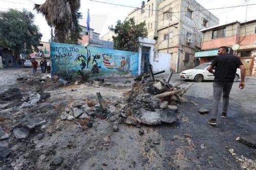epa10879978 A man walks along the remains of a road barrier at the Nur Shams refugee camp near the West Bank city of Tulkarem, 24 September 2023, following a military operation by the Israeli Army earlier the same day. According to the Palestinian Health Ministry, two Palestinians were killed in the raid in which Israeli forces destroyed the main road and...