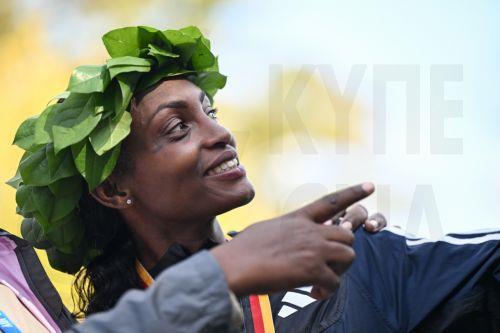 epa10880242 Winner Tigst Assefa of Ethiopia celebrates during the flower ceremony for the women's race of the Berlin Marathon 2023, in Berlin, Germany, 24 September 2023. Assefa set a new women's world record of 2:11:53.  EPA/Filip Singer