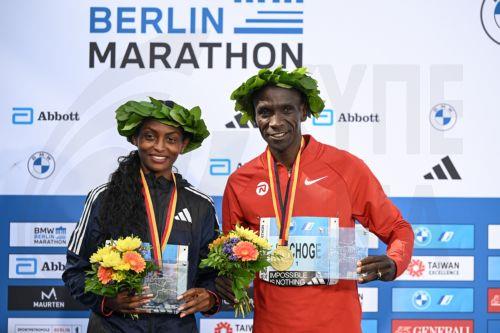 epa10880258 Womenâ€™s winner Tigst Assefa of Ethiopia (L) and Menâ€™s winner Eliud Kipchoge of Kenya (R) celebrate during the flower ceremony of the Berlin Marathon 2023, in Berlin, Germany, 24 September 2023. Assefa set a new women's world record of 2:11:53.  EPA/Filip Singer