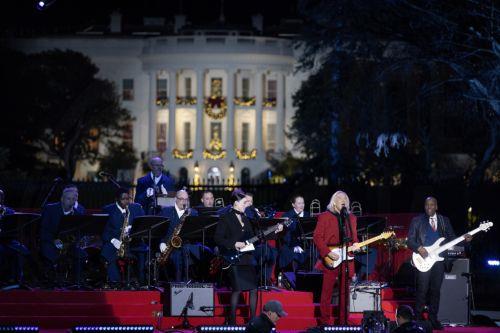 epa11004926 US music artists Joe Walsh (C) and St. Vincent (L) perform during the lighting of the National Christmas Tree on the Ellipse near the White House, in Washington, DC, USA, 30 November 2023. The lighting of the tree is an annual tradition attended by the US President and the First Family. President Calvin Coolidge lit the first National Christmas...