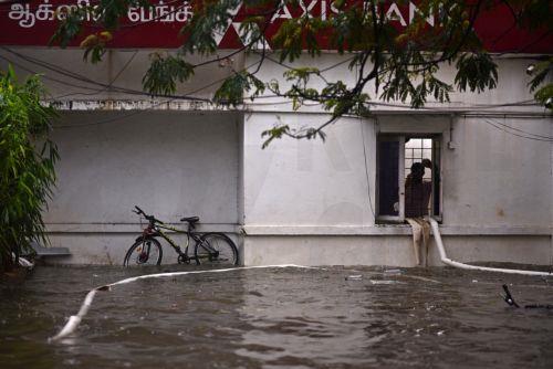 epa11010533 A man looks out from a bank at a flooded locality during heavy rains as Cyclone Michaug is expected to make landfall on the eastern Indian coast, in Chennai, India, 04 December 2023. The Indian Meteorological Department has issued a red alert for heavy rains in Chennai as the cyclonic storm, 'Cyclone Michaung' is anticipated to make landfall...