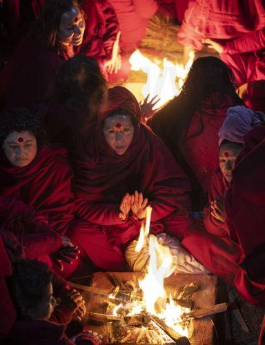 epaselect epa11117224 Nepalese Hindu women warm themselves by a fire after taking a mass holy bath in the Salinadi River during the Madhav Narayan festival in Sankhu, on the outskirts of Kathmandu, Nepal, 01 February 2024. The Madhav Narayan festival is a full month-long event devoted to religious fasting, holy bathing and the study of the Swasthani book,...