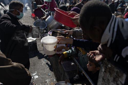 epa11118496 Displaced Palestinians hold empty pots and buckets as they line up to receive food aid provided by a Palestinian youth group, at Rafah refugee camp, southern Gaza Strip, 01 February 2024. Since 07 October 2023, up to 1.9 million people, or more than 85 percent of the population, have been displaced throughout the Gaza Strip, some more than once,...