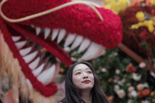epa11133169 A woman walks past a statue of a dragon on the street installed as a decoration for the upcoming Chinese New Year, in Shanghai, China, 07 February 2024. The Chinese Lunar New Year, also called 'Spring Festival', will fall on 10 February 2024, marking the beginning of the Year of the Dragon.  EPA/ALEX PLAVEVSKI
