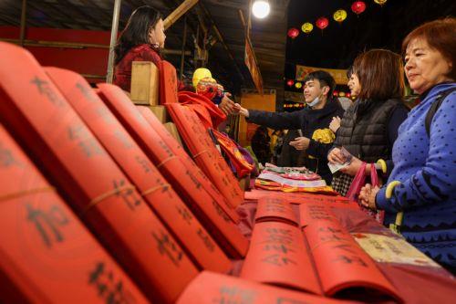 epa11134016 People buy various spring couplets ahead of the Chinese Lunar new year celebration in Taipei, Taiwan, 07 February 2024. The Lunar New Year, also known as Spring Festival , falls on 10 February in 2024, marking the beginning of the Year of the Dragon. The spring couplets contain auspicious and rhyming poetic words for the new year, usually...