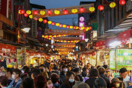 epa11134033 People shopping past Chinese ornaments decorations ahead of the Chinese Lunar new year celebration in Taipei, Taiwan, 07 February 2024. The Lunar New Year, also known as Spring Festival , falls on 10 February in 2024, marking the beginning of the Year of the Dragon.  EPA/RITCHIE B. TONGO