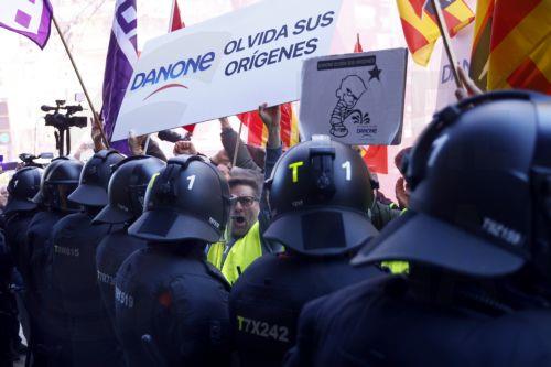 epa11147417 A worker holding a banner reading 'Danone forget its origins', as some workers of dairy products giant protest in front of Danone's offices in Barcelona, to protest against the closing down of company's plant of Parets del Valles (Barcelona), northeastern Spain, 12 February 2024. The company announced in January the closure of the plant that has...