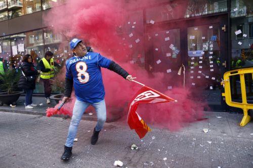 epa11147422 A worker holding a flare attend a rally called by workers of dairy products giant Danone in front of company's offices in Barcelona, to protest against the closing down of company's plant of Parets del Valles (Barcelona), northeastern Spain, 12 February 2024. The company announced in January the closure of the plant that has a workforce of 157...