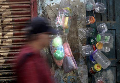 epa11165653 An Indian commuter walks past plastic items displayed for sale in Kolkata, eastern India, 19 February 2024. The volume of plastic waste is growing and it has turned into a big peril for India's cities, clogging sewers, drains and polluting water bodies.  EPA/PIYAL ADHIKARY