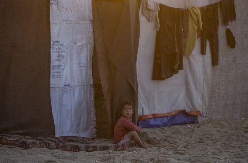 epa11317097 A displaced Palestinian boy who fled with his family from the northern Gaza strip plays outside their shelter at Deir Al Balah beach in the southern Gaza Strip, 03 May 2024. More than 34,550 Palestinians and over 1,455 Israelis have been killed, according to the Palestinian Health Ministry and the Israel Defense Forces (IDF), since Hamas...