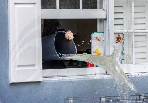 epa11408201 A person throws water through a window in a flooded neighborhood in Hallandale Beach, Florida, USA, 13 June 2024. Heavy rains triggered a flash flood and the Broward and Miami-Dade counties saw record rainfall amounts in a matter of hours, ranging from 15 inches to 26 inches, the National Weather Service said.  EPA/CRISTOBAL HERRERA-ULASHKEVICH