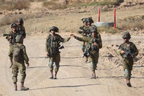 epa11408272 Two Israeli soldiers (C) gesture as they patrol along the border with the Gaza Strip, at an undisclosed location in southern Israel, 13 June 2024. The Israeli military stated on 13 June that its troops are continuing to operate against 'terrorist infrastructure and operatives' in the Gaza Strip. More than 37,000 Palestinians and over 1,400...