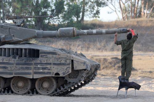 epa11408285 An Israeli soldier inspects the cannon of a tank at an undisclosed location near the border with the Gaza Strip, in southern Israel, 13 June 2024. The Israeli military stated on 13 June that its troops are continuing to operate against 'terrorist infrastructure and operatives' in the Gaza Strip. More than 37,000 Palestinians and over 1,400...