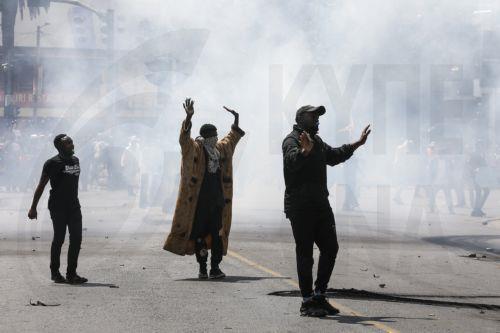 epa11436097 Demonstrators react while being shrouded in teargas during a protest against proposed tax hikes, in Nairobi, Kenya, 25 June 2024. Kenya's police on 25 June have sealed off the parliament and State House, and fired tear gas to disperse protesters demonstrating against planned tax hikes that many fear will worsen the cost-of-living crisis. ...