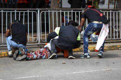 epa11436101 A group of men attend to an injured demonstrator during a protest against proposed tax hikes, in Nairobi, Kenya, 25 June 2024. Kenya's police on 25 June have sealed off the parliament and State House, and fired tear gas to disperse protesters demonstrating against planned tax hikes that many fear will worsen the cost-of-living crisis. ...