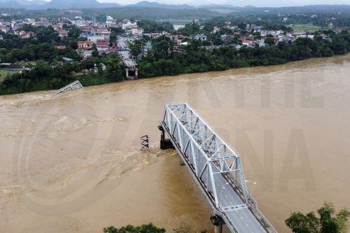 epa11594352 A handout photo made available by Vietnam News Agency shows an aerial view of the partially collapsed Phong Chau bridge into Red River, in Phu Tho province, northern Vietnam, 09 September 2024. According to state media, three people have been rescued and at least thirteen are missing following the collapse of the bridge into Red River on 09...