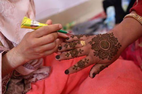 epa11605331 A bride decorates her hands with henna during a mass marriage ceremony in Srinagarr, the summer capital of Indian Kashmir, 15 September 2024. A total of 60 orphan girls and low-income couples got married during a mass ceremony organized by the non-governmental organization (NGO) 'J&K Al Noor Yateem Trust' to provide financial support to families...