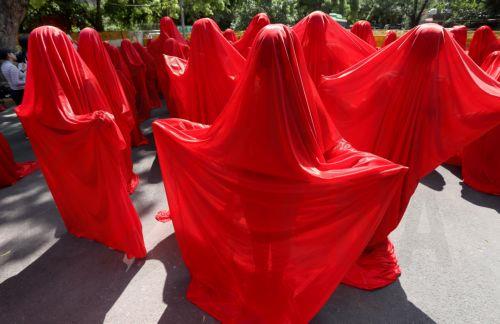 epa11627988 Activists from the People for the Ethical Treatment of Animals (PETA) India stage a protest in New Delhi, India, 27 September 2024. Dozens of activists dressed in 'blood red' veils and wearing horns demonstrated to demand an end to violence against animals in events such as races, fights and jallikattu.  EPA/HARISH TYAGI