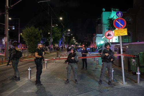 epa11636272 Armed Israeli police officers keep watch near a cordon at the site of a shooting incident in Tel Aviv, Israel, 01 October 2024. According to Israeli police, at least eight people were killed and nine others wounded in a shooting incident on Sderot Yerushalim in Tel Aviv. Two gunmen have been 'neutralized' on site, police said.  EPA/ABIR SULTAN