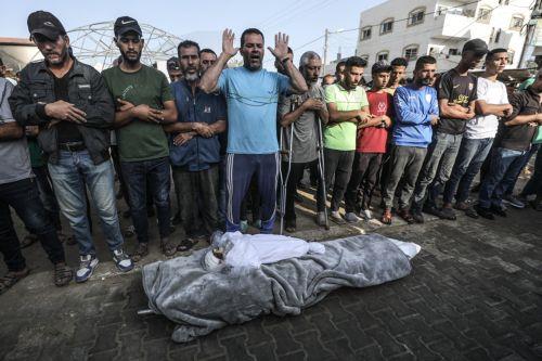epa11657999 Relatives of killed one-and-a-half-year old baby Yaman Al Zaneen pray beside his body during his funeral in Deir al Balah, central Gaza Strip, 14 October 2024. According to the Palestinian Ministry of Health, 23 people, including children, were killed after a school sheltering internally displaced Palestinians in Nuseirat camp was struck by an...