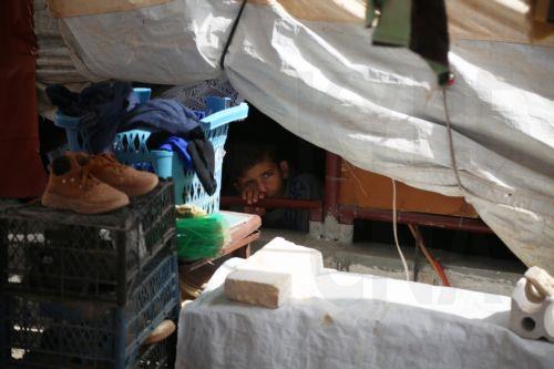 epa11659202 A displaced child looks from inside a shelter at a camp of Internally Displaced People (IDP) at Ma'arrat Misrin, Idlib, northwest Syria, 14 October 2024. Carden arrived in northwest Syria to inspect camps of displaced Syrians, the distribution of food aid provided by the WFP and meet with Syrians who fled the hostilities in Lebanon amid the...