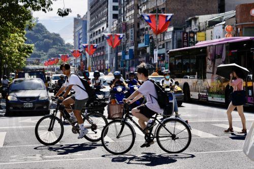 epa11659851 Pedestrians cross the street in Taipei, Taiwan, 15 October 2024. On 14 October, China flew a record 125 warplanes near Taiwan during the 'Joint Sword 2024-B'  military drills, according to Taiwan's Ministry of National Defense.  EPA/RITCHIE B. TONGO