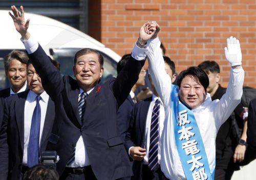epa11659871 Japanese Prime Minister Shigeru Ishiba (L) raises his arms with a ruling Liberal Democratic Party (LDP) candidate during an election campaign rally at Onahama Fish Market in Iwaki, Fukushima prefecture, northeastern Japan, 15 October 2024. Prime Minister Ishiba made his first speech at the kick-off of the official campaigning for the 27 October...
