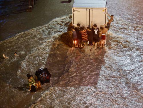 epa11679563 Residents wade on a flooded road in Las Pinas city, Metro Manila, Philippines, 24 October 2024. Tropical Storm Trami has caused floods and damage to infrastructure and properties in the Luzon and Visayas regions of the Philippines. The countryâ€™s weather bureau projects the stormâ€™s center near Ifugao province in the northern Philippines, with...