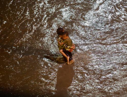 epa11679564 Residents wade on a flooded road in Las Pinas city, Metro Manila, Philippines, 24 October 2024. Tropical Storm Trami has caused floods and damage to infrastructure and properties in the Luzon and Visayas regions of the Philippines. The countryâ€™s weather bureau projects the stormâ€™s center near Ifugao province in the northern Philippines, with...