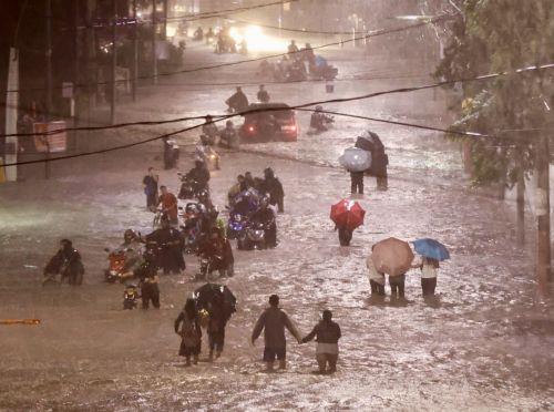 epa11679566 Residents wade on a flooded road in Las Pinas city, Metro Manila, Philippines, 24 October 2024. Tropical Storm Trami has caused floods and damage to infrastructure and properties in the Luzon and Visayas regions of the Philippines. The countryâ€™s weather bureau projects the stormâ€™s center near Ifugao province in the northern Philippines, with...