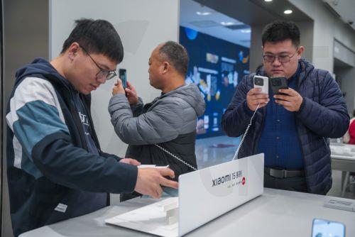 epa11691773 People check the latest models of Xiaomi 15 smartphones at a Xiaomi store in Beijing, China, 30 October 2024. Xiaomi released its new mobile phone products '15' and '15 Pro' on 29 October.  EPA/WU HAO