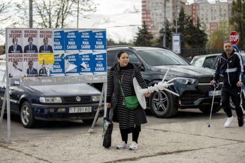 epa11694856 A woman walks in front of party posters stand in Chisinau, Moldova, 31 October 2024. Moldova will hold the second round of presidential election, between incumbent Moldovan President Maia Sandu and former prosecutor general Alexandr Stoianoglo, on 03 November 2024.  EPA/DUMITRU DORU