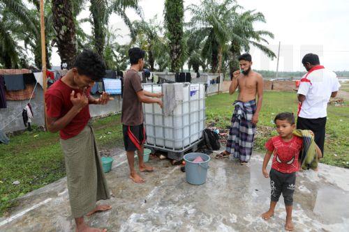 epa11695364 Rohingya refugees clean themselves in an open area outside of their temporary tents provided by the International Organization for Migration (IOM) in Seneubok Rawang village, East Aceh, Indonesia, 01 November 2024. 96 Rohingya immigrants landed in the Meunasa Hasan Village, Madat District, East Aceh Regency, on 31 October 2024. According to the...