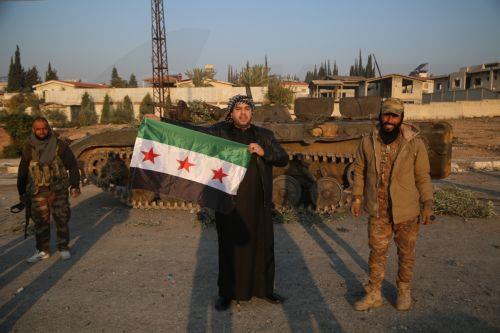epa11760249 A man (C) holds a flag of the Syrian opposition after Syrian opposition forces entered the city of Hama, Syria, 06 December 2024. Syrian opposition forces, led by the Islamist militant group Hayat Tahrir al-Sham (HTS), launched an offensive on 27 November, triggering counterattacks by the Syrian regime forces as well as Russian and Syrian...