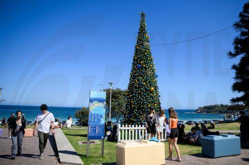 epa11792677 A Christmas tree is seen as people celebrate Christmas Day at Bondi Beach in Sydney, Australia, 25 December 2024.  EPA/BIANCA DE MARCHI AUSTRALIA AND NEW ZEALAND OUT