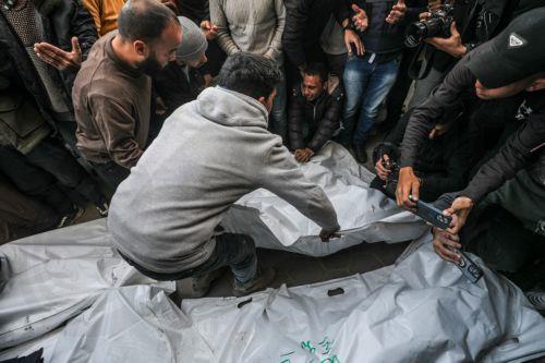 epa11793719 People mourn near the covered bodies of Palestinian journalists killed in an overnight Israeli airstrike in Al Nuseirat refugee camp, at Al Aqsa Martyrs Hospital in Deir Al Balah, central Gaza Strip, 26 December 2024. According to the Government Media Office (GMO) in Gaza, five journalists from the 'Al-Quds Today' TV satellite channel were...