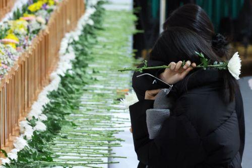 epa11798541 A mourner weeps for the victims of the 29 December Jeju Air plane crash at a joint memorial altar at Muan Sports Center in Muan, South Korea, 30 December 2024. According to the South Korea National Fire Agency (NFA), a passenger jet carrying 181 people erupted in flames after going off the runway at an airport in South Korea's southwestern...