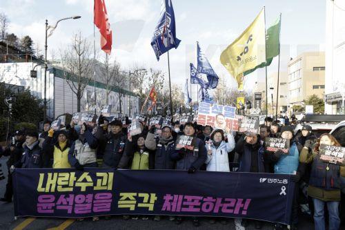 epaselect epa11803243 Members of the Korean Confederation of Trade Unions (KCTU) hold placards and banners reading 'Arrest Yoon Suk Yeol immediately' during a rally against impeached president Yoon near the presidential residence in Seoul, South Korea, 03 January 2025. A Seoul court on 31 December 2024 issued an arrest and search warrant to detain impeached...