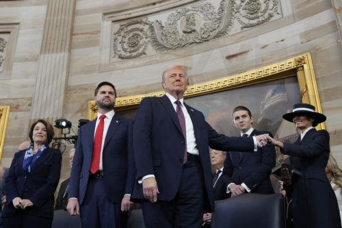 epa11839571 President Donald Trump, center, holds the hand of his wife Melania Trump, far right, as their son Barron Trump, Vice President JD Vance, and Sen. Amy Klobuchar, D-Minn., far left, look on after taking the oath of office during the 60th Presidential Inauguration in the Rotunda of the U.S. Capitol in Washington, Monday, Jan. 20, 2025.  EPA/Morry...