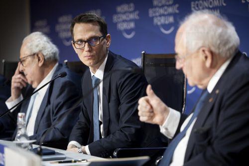 epa11847263 Chairman of the Governing Board of Swiss National Bank (SNB) Martin Schlegel (C) looks on between Julio Velarde (L), Governor of Central Bank of Peru, and Martin Wolf (R) Associate Editor and Chief Economics Commentator of Financial Times, during the 55th annual meeting of the World Economic Forum (WEF), in Davos, Switzerland, 23 January 2025. ...