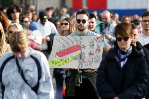 epa11856323 A protester holds a banner depicting the Serbian President Aleksandar Vucic and the Novi Sad railway station, during the blockade of the 'Autokomanda' intersection in Belgrade, Serbia, 27 January 2025. University students staged a protest, demanding accountability after fifteen people lost their lives in the collapse of the Novi Sad Railway...