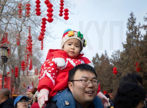 epa11865411 A man carries a child on his shoulders at a temple fair held during the Spring Festival, or Chinese New Year, at a park in Beijing, China, 31 January 2025. The holiday is celebrated from 28 January until 03 February this year, marking the beginning of the Year of the Snake.  EPA/JESSICA LEE