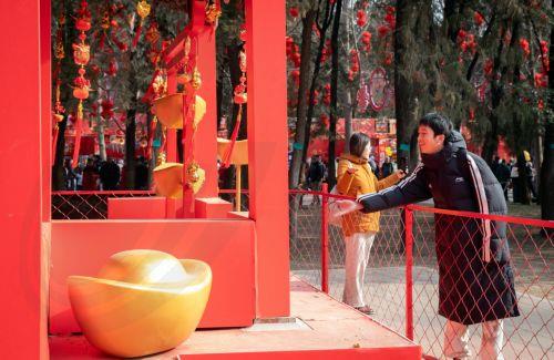 epa11865417 A person throws coins into a display at a temple fair held during the Spring Festival, or Chinese New Year, at a park in Beijing, China, 31 January 2025. The holiday is celebrated from 28 January until 03 February this year, marking the beginning of the Year of the Snake.  EPA/JESSICA LEE