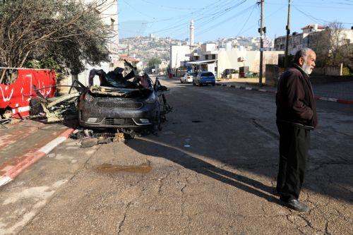 epa11869791 A Palestinian man stands near a car wreckage following an Israeli airstrike in Qabatiya village, near the West Bank city of Jenin, 02 February 2025. Over two dozen Palestinians have been killed, according to the Palestinian Ministry of Health, and one Israeli soldier killed, according to the Israeli army, since the start of the Israeli military...