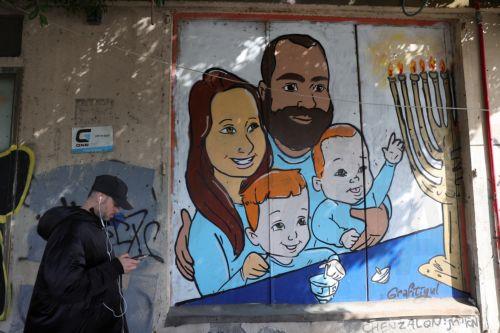 epa11909834 A man walks past a graffiti of the Bibas family in Tel Aviv, Israel, 20 February 2025. Hamas on 20 February handed over the bodies of four Israeli captives, including that of youngest hostage Kfir Bibas, as part of the ongoing Gaza ceasefire deal. Hamas said in November 2023 that the two Bibas boys and their mother had been killed in an Israeli...
