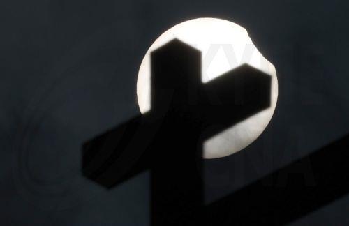epa11996921 The partial solar eclipse as seen behind a cross on a church in Moscow, Russia, 29 March 2025. A solar eclipse happens when the Moon passes between the Sun and Earth, casting a shadow on Earth that either fully or partially blocks the Sun's light in some areas.  EPA/MAXIM SHIPENKOV